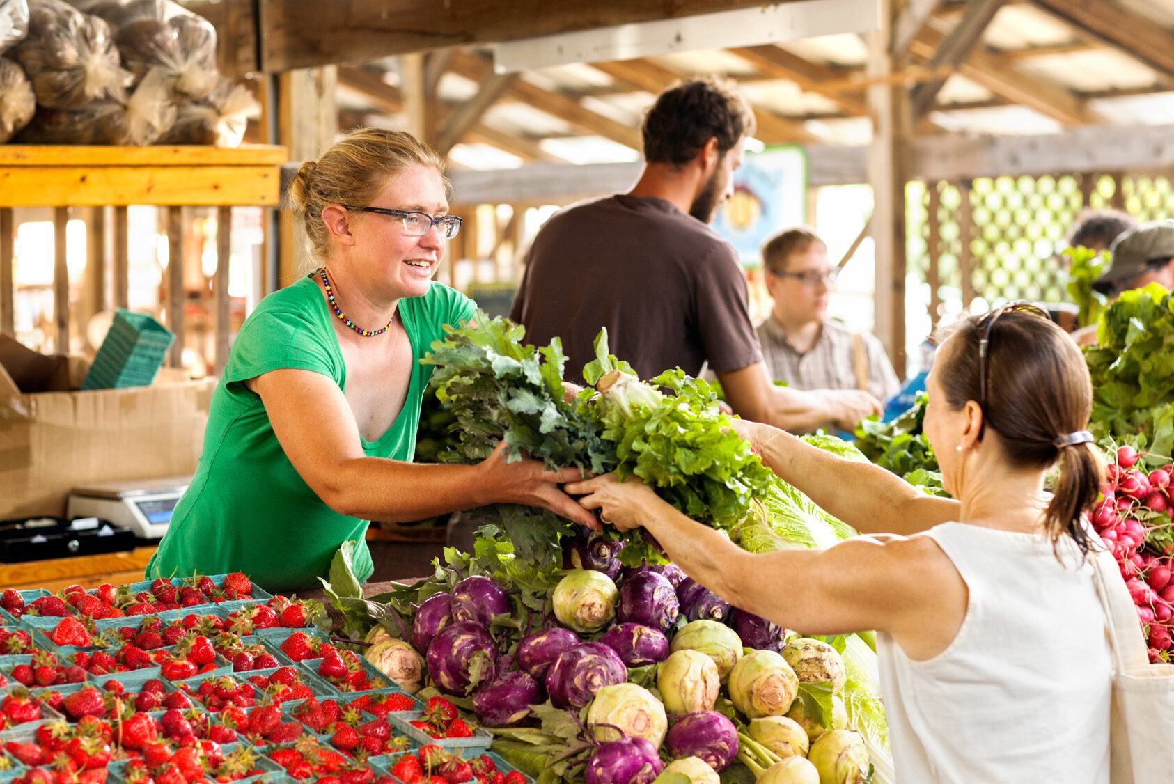 A customer buys produce in one of the region's many farmer's markets