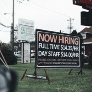 A road sign advertising available jobs. "Now Hiring"