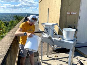 Hunter Jamison uses a wet and dry deposition ACM NTN collector on the roof of Snee Hall to collect rainfall and dust. The collector is on loan from the National Atmospheric Deposition Program National Trends Network Ithaca site.