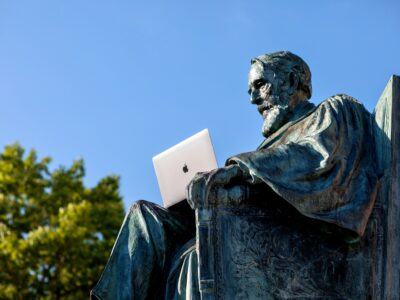 statue holding laptop