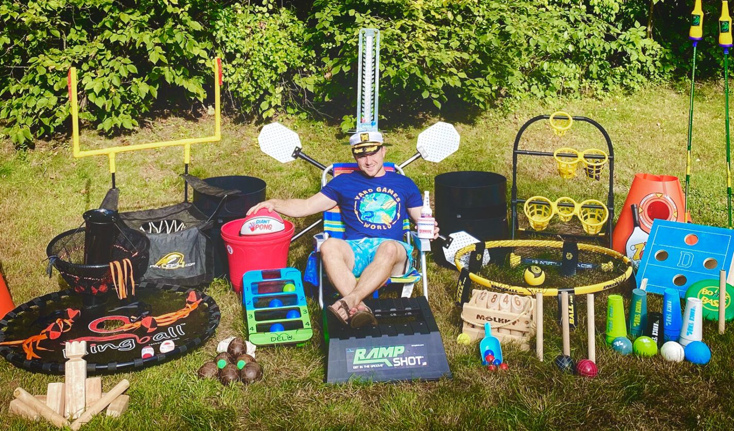 man sitting surrounded by yard games