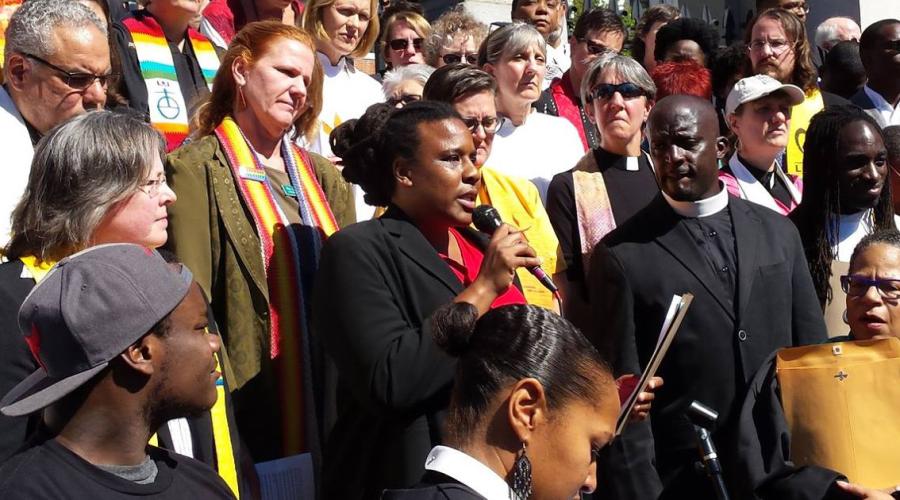 Nia Evans ’00 makes a speech among community leaders