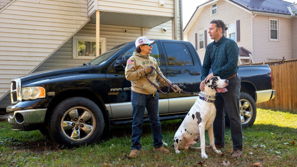 A veteran and her dog stand with the supervising attorney of the Veterans Law Practicum