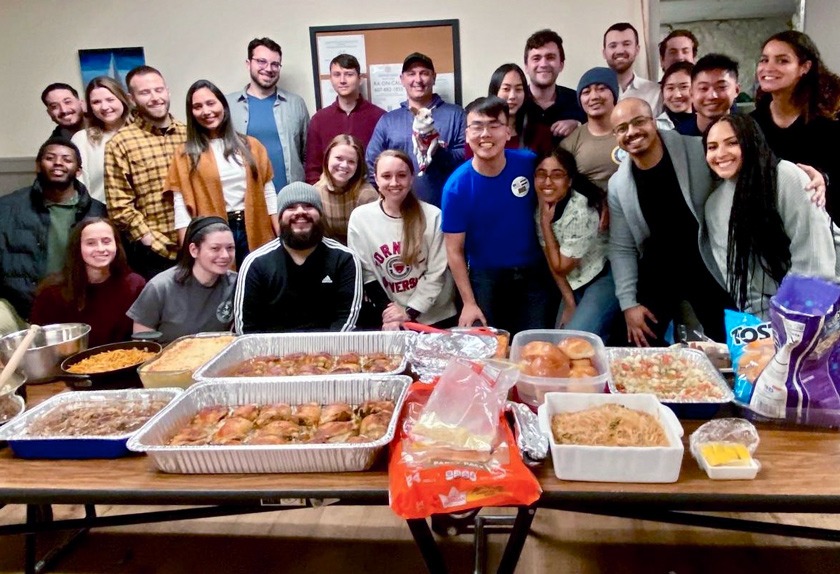 Indigo Routh ’24 (center, in Cornell sweatshirt) at the annual Friendsgiving potluck gathering in 2022 at the Veteran Program House