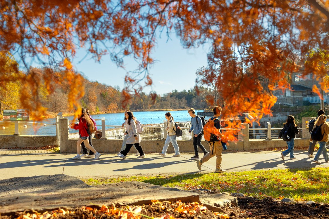 Students cross Beebe footbridge on a fall morning.
