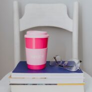 reusable coffee cup on stack of books