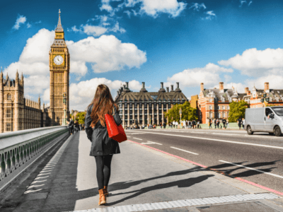 Woman with red bag walking toward Big Ben in London