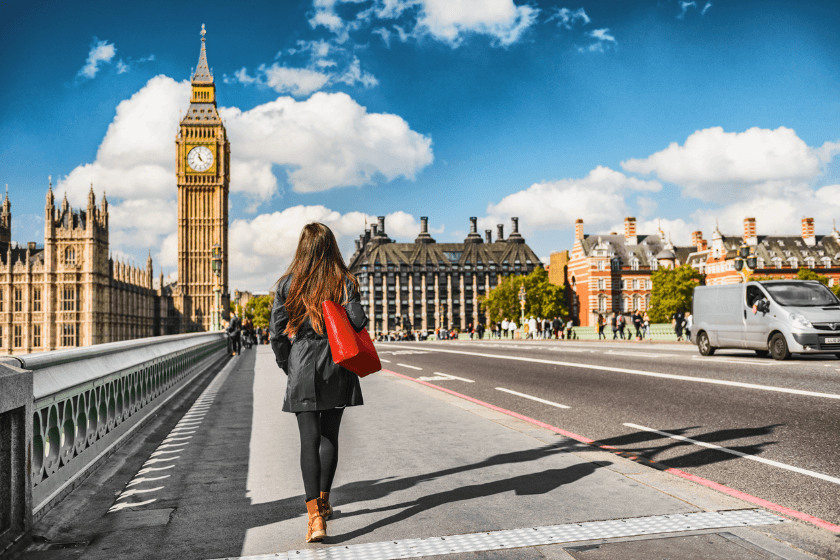 Woman with red bag walking toward Big Ben in London