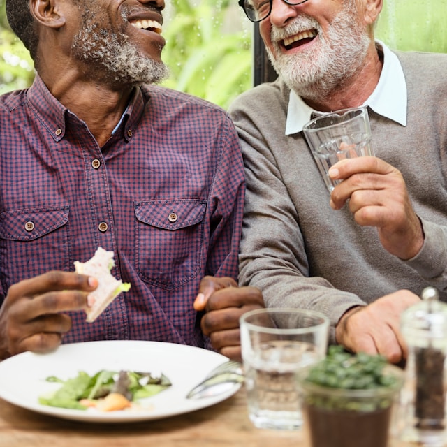 Two men laughing over lunch