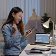 A young entrepreneur smiling down at her phone.
