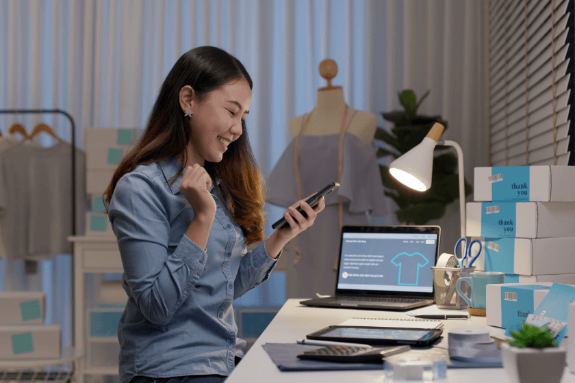 A young entrepreneur smiling down at her phone.