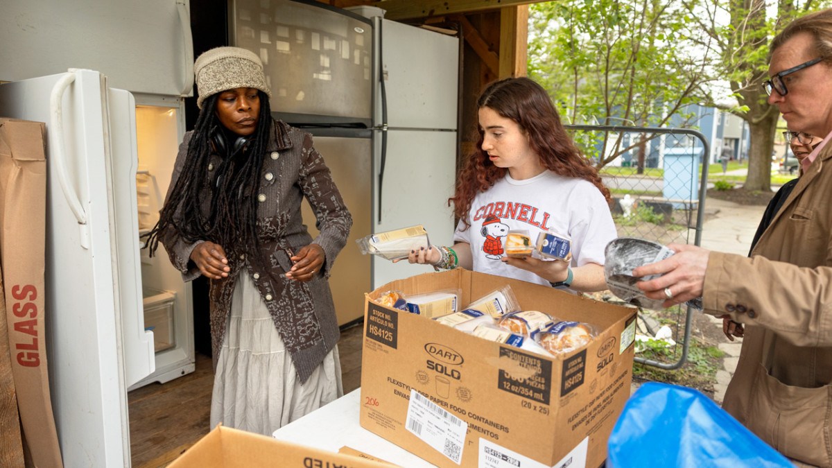 Through her work with the student-run Food Recovery Network, Jenna Rosenberg '29 (center) stocks donations of leftover food with community members in downtown Ithaca.