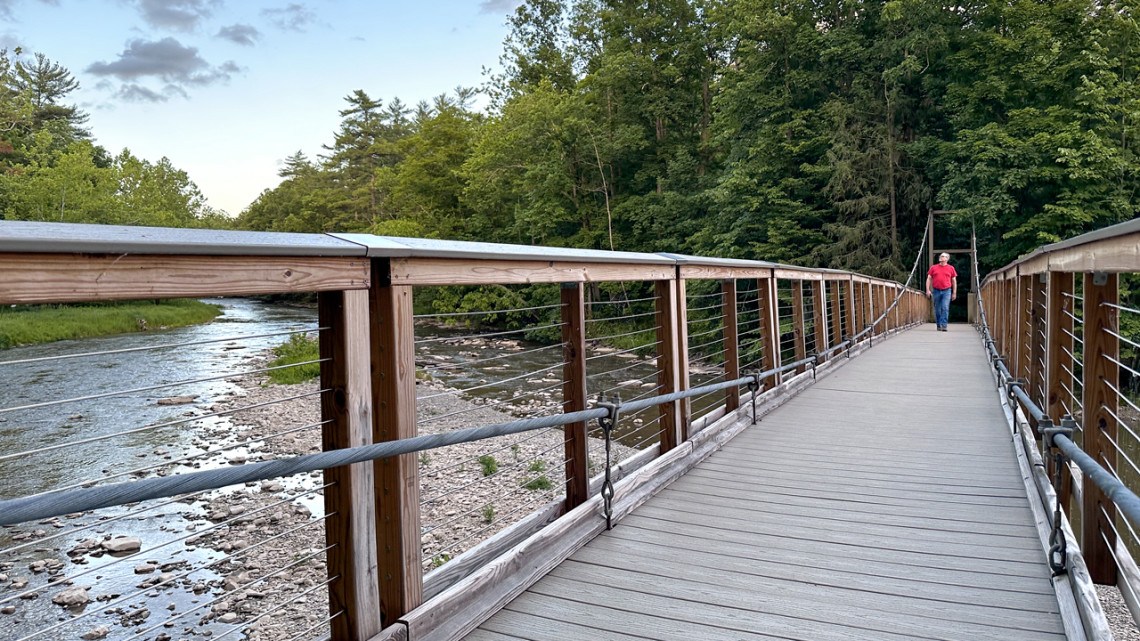 A pedestrian footbridge that crosses Fall Creek in an area of the Cornell Botanic Gardens known as Flat Rock was rebuilt by Cornell students in 2023.