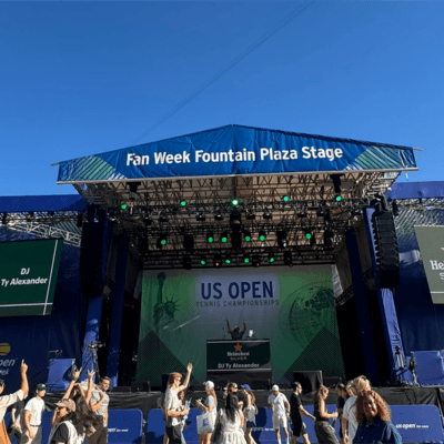 US Open Fan Week stage outside with people dancing in front of it